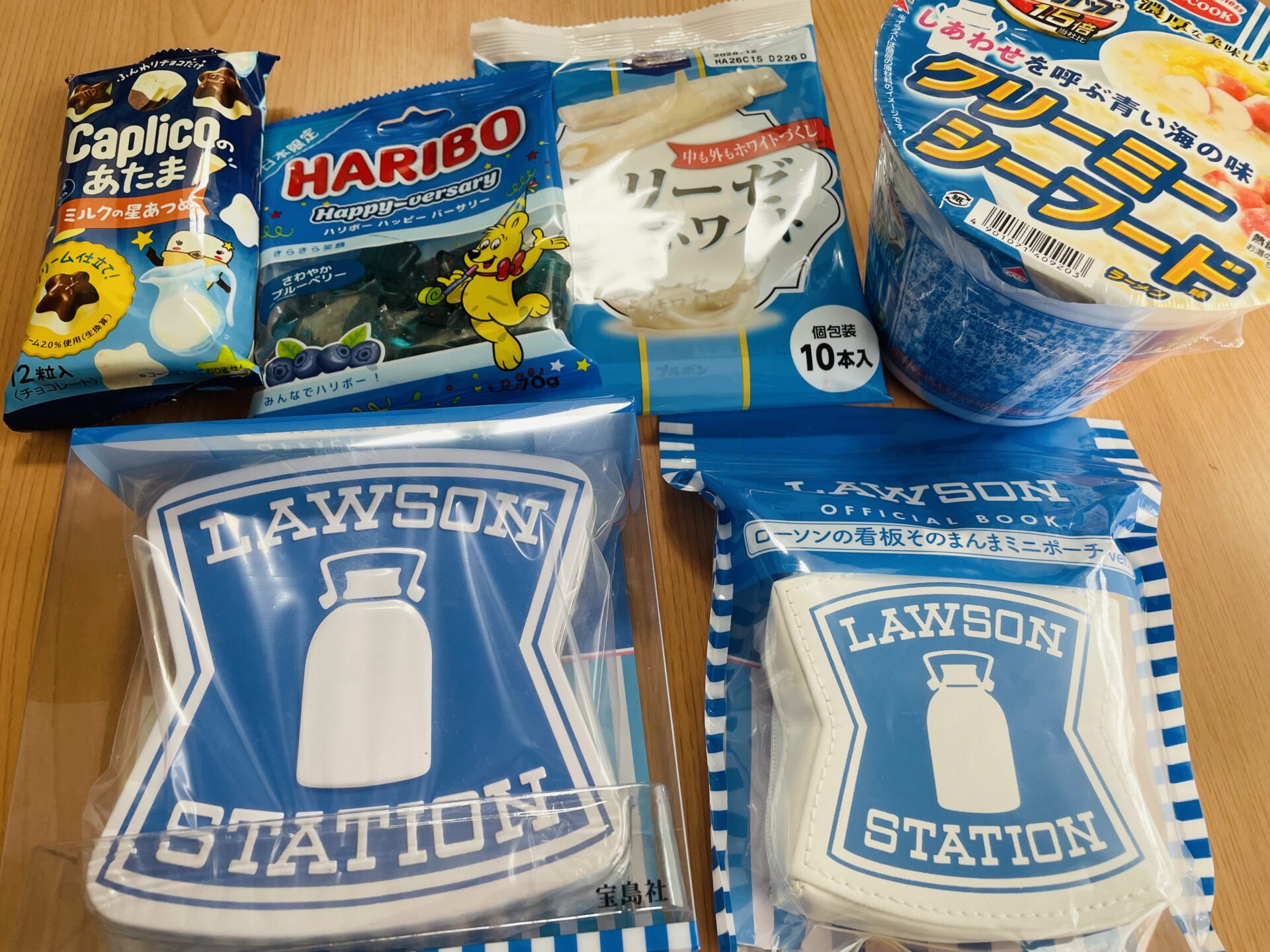 ローソンの看板ミニポーチ、お楽しみ文具セット、限定の青いお菓子（エリーゼ、スーパーカップなど）、からあげクン靴下の購入品集合写真